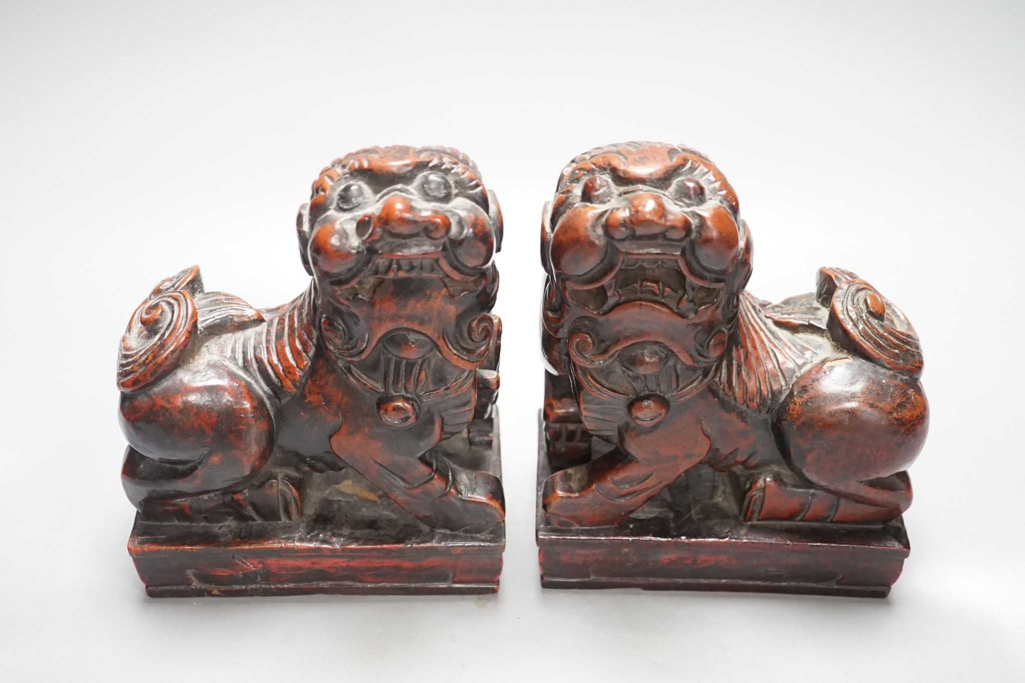 A pair of Japanese carved and red lacquered wood models of temple dogs, Edo period, 21.5 cms high.